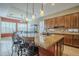 Kitchen island with seating, granite countertops, stainless steel appliances, and wood cabinets at 4497 E Ficus Way, Gilbert, AZ 85298