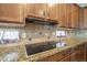 Kitchen with granite counters, tile backsplash, and wooden cabinets at 4497 E Ficus Way, Gilbert, AZ 85298