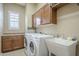 The laundry room features a sink, cabinetry, and a front-load washer and dryer at 4497 E Ficus Way, Gilbert, AZ 85298
