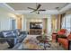 Spacious living room featuring a media center, dual sofas, ceiling fan, and elegant furnishings at 4497 E Ficus Way, Gilbert, AZ 85298