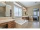 Bright main bathroom showcasing a garden tub, double sink vanities, and convenient access to other rooms at 4497 E Ficus Way, Gilbert, AZ 85298