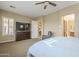 Relaxing main bedroom featuring neutral tones, a ceiling fan, sitting area, and media center at 4497 E Ficus Way, Gilbert, AZ 85298