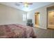 The primary bedroom offers neutral colors, a ceiling fan, and a view into an en suite bathroom at 4497 E Ficus Way, Gilbert, AZ 85298