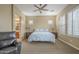 Spacious main bedroom featuring neutral tones, ceiling fan, plantation shutters, and relaxing sitting area at 4497 E Ficus Way, Gilbert, AZ 85298