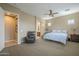 Bright main bedroom featuring neutral tones, a ceiling fan, relaxing sitting area, and ensuite bath access at 4497 E Ficus Way, Gilbert, AZ 85298