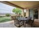 Comfortable patio with an outdoor dining set with a view of the artificial turf lawn and backyard at 4497 E Ficus Way, Gilbert, AZ 85298