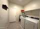 Functional laundry room featuring a washer, dryer, utility sink, and ample storage shelves at 4774 E Chromium Rd, San Tan Valley, AZ 85143