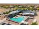 Aerial view of a community pool with ample seating and umbrellas near well-maintained homes and desert landscaping at 4774 E Chromium Rd, San Tan Valley, AZ 85143