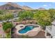 Aerial view of pool and backyard surrounded by desert landscape and the desert mountain range at 5042 W Lariat Ln, Phoenix, AZ 85083