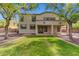 View of the home's exterior from a spacious backyard featuring a lush lawn and mature trees at 5042 W Lariat Ln, Phoenix, AZ 85083