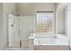 Bathroom featuring a glass shower, soaking tub, glass block window and tile floor at 5042 W Lariat Ln, Phoenix, AZ 85083