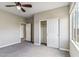Comfortable bedroom with light gray carpet, ceiling fan, neutral paint, and closet with sliding doors at 5042 W Lariat Ln, Phoenix, AZ 85083