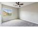 This cozy bedroom features a ceiling fan, gray walls, gray carpet, and one window at 5042 W Lariat Ln, Phoenix, AZ 85083