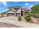 Charming two-story stucco home with desert landscaping, a three-car garage, and brick walkway at 5042 W Lariat Ln, Phoenix, AZ 85083