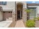 Close up of the front entry with desert landscaping, brick walkway and three-car garage at 5042 W Lariat Ln, Phoenix, AZ 85083