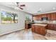 Kitchen featuring granite counters, wood cabinets, island, and backyard views at 5042 W Lariat Ln, Phoenix, AZ 85083