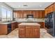 Kitchen with dark wood cabinets, tile floors, granite countertops, and black appliances at 5042 W Lariat Ln, Phoenix, AZ 85083