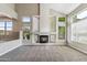 An open-concept living room with a fireplace, carpeted floor, multiple windows, and high ceilings at 5042 W Lariat Ln, Phoenix, AZ 85083
