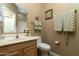 Bright bathroom featuring a toilet, sink with wood cabinets, towels, and neutral-toned walls at 5118 S Morning Sky Trl, Gold Canyon, AZ 85118