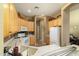Bright kitchen with white appliances, light wood cabinets, and tile floors at 5118 S Morning Sky Trl, Gold Canyon, AZ 85118