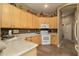 Charming kitchen with light wood cabinets, white appliances, and durable tile flooring at 5118 S Morning Sky Trl, Gold Canyon, AZ 85118
