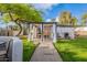 Spacious backyard featuring a covered patio, landscaped gravel path, and lush green lawn, perfect for relaxation at 541 W Palm Ln, Phoenix, AZ 85003