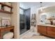 Modern bathroom featuring a glass shower, wood vanity, decorative accents, and unique tile flooring at 541 W Palm Ln, Phoenix, AZ 85003