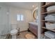 A well-lit bathroom featuring a walk-in shower, a wooden vanity, and a round mirror at 541 W Palm Ln, Phoenix, AZ 85003