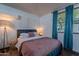This bedroom features a comfortable bed with blue trim, a cozy lamp, and natural light from a nearby window at 541 W Palm Ln, Phoenix, AZ 85003