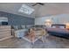 Bright bedroom featuring a large gray sectional sofa, a bed with pink and blue bedding, and a charming wicker chair at 541 W Palm Ln, Phoenix, AZ 85003