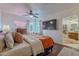 Stylish bedroom features a large flat screen tv, ceiling fan, and connecting bathroom at 541 W Palm Ln, Phoenix, AZ 85003