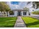 Charming single-story home with lush green lawn, stone pathway, and classic architectural details at 541 W Palm Ln, Phoenix, AZ 85003
