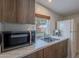 A kitchen featuring a white refrigerator, a stainless steel microwave, and wood-grain cabinets beneath a window at 541 W Palm Ln, Phoenix, AZ 85003