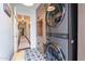 Functional laundry room with washer-dryer units, patterned flooring, and hallway access at 541 W Palm Ln, Phoenix, AZ 85003