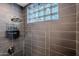 Sleek shower with grey tiling, glass block window, and mounted shower head at 541 W Palm Ln, Phoenix, AZ 85003