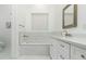 Bright bathroom featuring a soaking tub, modern vanity with ample storage, and marble tiling at 6244 S Flora Ln, Gold Canyon, AZ 85118