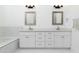 Bright bathroom featuring double sinks, a modern vanity, framed mirrors, and ample storage space at 6244 S Flora Ln, Gold Canyon, AZ 85118