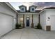 Inviting front entrance with stone pillar accents, a dark blue door, and three-car garage at 6244 S Flora Ln, Gold Canyon, AZ 85118