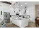Modern white kitchen with stainless steel appliances, a large island, and pendant lighting at 6244 S Flora Ln, Gold Canyon, AZ 85118