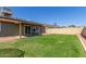 View of the backyard with green grass, patio, and partial solar panels at 6413 W Monte Cristo Ave, Glendale, AZ 85306