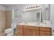Bathroom features a double sink vanity with light wood cabinets and a large mirror at 6413 W Monte Cristo Ave, Glendale, AZ 85306