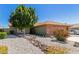 Single-story home with a desert front yard, rock water feature, and brick accents on the garage at 6413 W Monte Cristo Ave, Glendale, AZ 85306