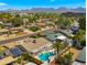 An aerial view of a neighborhood showcasing a community pool and mountain views at 6833 E Grandview Dr, Scottsdale, AZ 85254