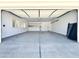 Open garage featuring epoxy flooring, bright lighting, windows, and a well-organized storage area at 6833 E Grandview Dr, Scottsdale, AZ 85254