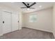 Neutral bedroom featuring a carpeted floor, ceiling fan, and a double door closet at 6908 W Wanda Lynn Ln, Peoria, AZ 85382