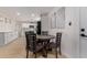 Eat-in dining area featuring a round wooden table and chairs, next to a kitchen with white cabinets at 6908 W Wanda Lynn Ln, Peoria, AZ 85382