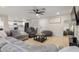 Bright living room featuring a gray sofa, open layout, and view into the modern kitchen at 6908 W Wanda Lynn Ln, Peoria, AZ 85382