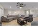 Spacious living room featuring a large sectional sofa, open layout, and modern ceiling fan at 6908 W Wanda Lynn Ln, Peoria, AZ 85382
