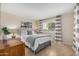 Cozy bedroom with a plush bed, neutral tones, and a window with striped curtains at 7800 E Lincoln Dr # 1035, Scottsdale, AZ 85250