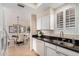 Well-lit kitchen with stone tile, white cabinets, black counters, and stainless steel sink at 7800 E Lincoln Dr # 1035, Scottsdale, AZ 85250